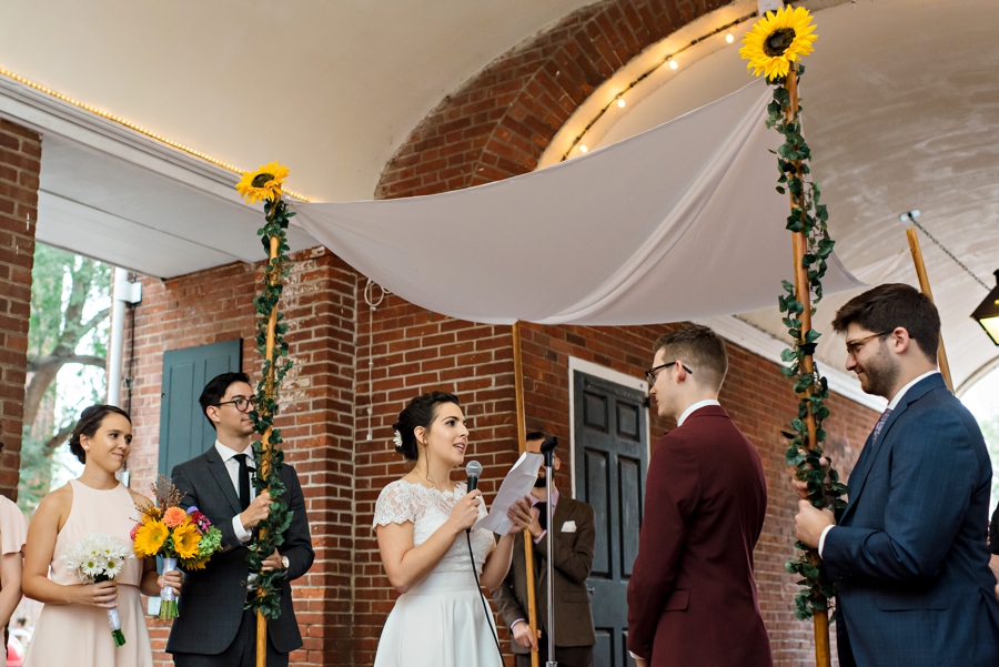 A bride reading her vows to her groom under the Chuppah.